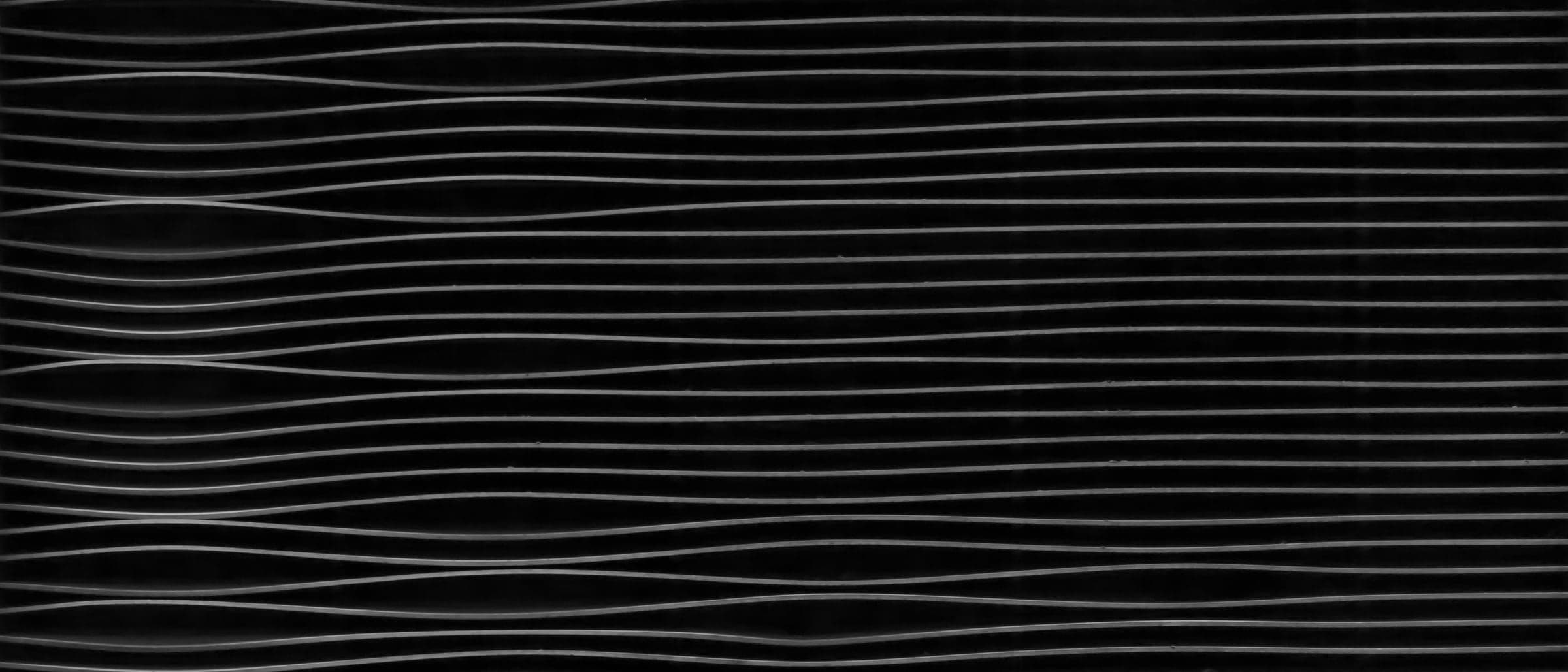 Fine parallel lines bending in gentle waves across a black surface.